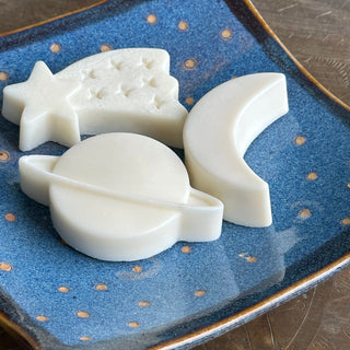 Three soaps on a blue ceramic dish with yellow dots (the night sky). 

Soaps are moon, planet (with a ring), and shooting star (5 pointed star with trailing tail indented with stars)