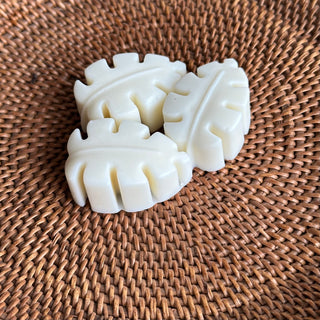 Three small tropical leaf shaped soaps, on a hand-woven basket.